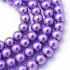 three strands of purple pearl beads on a white background