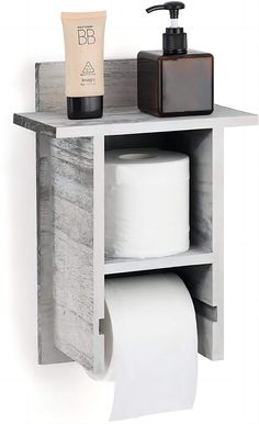 a bathroom shelf with two rolls of toilet paper and a soap dispenser