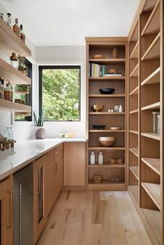 a kitchen filled with lots of wooden shelves