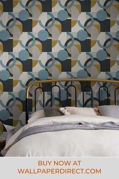 a bed sitting next to a wallpaper covered in blue and yellow circles