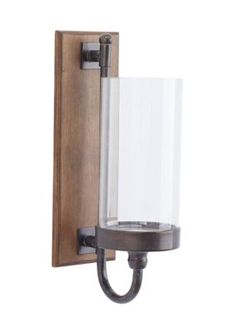 a wall light with a glass shade on the front and back of it's arm