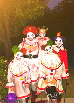 group of clowns dressed in costumes posing for the camera