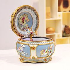 an elaborately decorated box with a carousel on it's lid sits on a table