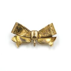 "Little gold tone bow brooch. This piece was likely born of the Victorian age. The mechanism has been replaced with a more modern piece (with lots of extra solder). There is an open jump ring on the back that may have had something hanging originally. Unmarked/unsigned. This piece shows signs of age but is still in wearable condition.  Measures: 1.25\" Long x .67\" Tall Weighs: 3.05 grams Please feel free to contact me with questions and/or for additional photos. More bows in the shop: Paste rhinestone brooch - www.etsy.com/BaseFare/listing/1257719220 Bow & locket brooch - www.etsy.com/BaseFare/listing/1349567107 *Free Shipping on Domestic Orders Over $35* All orders ship USPS First Class. If you would like to add insurance please reach out before purchase. All of our items are in good, vi Vintage Bow Tie Brooch As Gift, Gold Bow Brooches For Formal Occasions, Formal Gold Brooch With Bow, Vintage Bow Tie Brooch For Formal Occasions, Vintage Gold Brooch With Bow, Gold Vintage Brooch With Bow, Gold Ribbon Brooches For Gifts, Gold Ribbon Brooches As Gift, Gold Brooches With Ribbon Ideal For Gifts