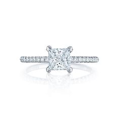 an engagement ring with a princess cut diamond in the center and pave set shoulders