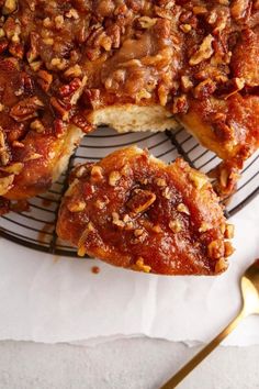 a close up of a cake on a plate with pecans in the middle and one slice missing