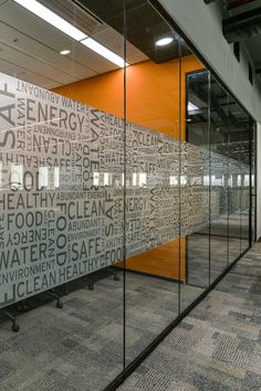 an office cubicle with glass walls and writing on the wall