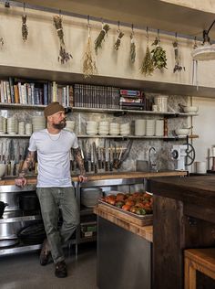 a man standing in front of a counter filled with lots of food and cooking utensils