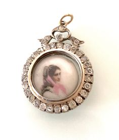 Antique Edwardian Silver 925 Bow design Locket with a gold wash over colour and surrounding glass paste gem stones all gem stones are original and secure as well as in unusually excellent condition - very clean . Locket holds a miniature hand painted ? image on porcelain inside of a young woman with pink scarf - with the stamp mark "5" on its reverse. Diameter of locket is approx 2.5 cm The open jump ring is 18ct Gold This is not marked for silver but has a pawnbrokers details etched on one side Antique Jeweled Jewelry, Antique Jeweled Silver Jewelry, Ornate Collectible Diamond Jewelry, Antique Silver Jeweled Jewelry, Ornate Collectible Rose Cut Diamond Jewelry, Ornate Diamond Jewelry Collectible, Ornate Rose Cut Diamond Collectible Jewelry, Ornate Diamond Jewelry For Collectors, Ornate Rose Cut Diamonds Jewelry Collectible