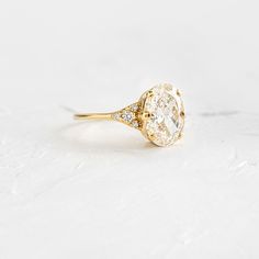 a yellow gold ring with an oval cut diamond