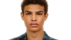 a young man making a funny face while wearing a blue and yellow shirt with his tongue sticking out