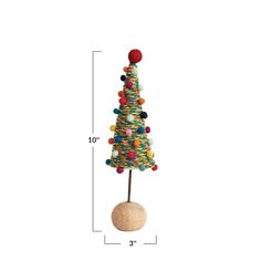 a toy christmas tree on top of a wooden ball