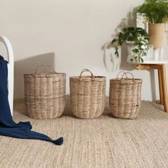 three baskets sitting on the floor next to a chair