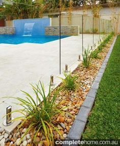 an empty backyard with a pool and landscaping