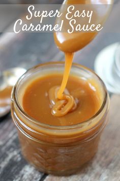 a spoon pouring caramel sauce into a jar on a wooden table with the words super easy caramel sauce