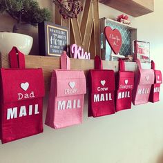 pink shopping bags hanging on the wall in front of a shelf with pictures and other items