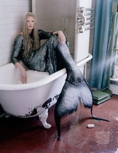 a woman sitting in a bathtub with her legs spread out