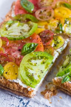 there is a piece of bread with tomatoes and cucumbers on it, cut in half