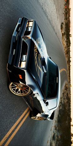 the top view of a black sports car with gold accents on it's hood