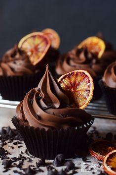 chocolate cupcakes with orange slices and chocolate frosting