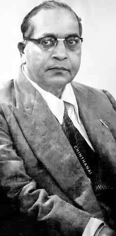 a black and white photo of a man in a suit with glasses on his head