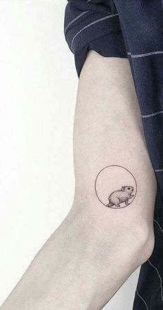 a person with a small tattoo on their arm that has an animal in the middle