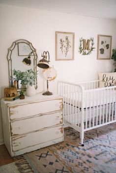 a baby's room with a dresser, crib and pictures on the wall