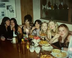 a group of women sitting around a table eating food