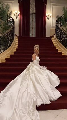 a woman in a white dress standing on some stairs