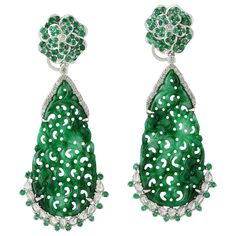 These stunning hand carved Jade earrings are crafted in 18-karat gold. It is set in 20.85 carats Jade, 1.71 carats emerald and .28 carats of sparkling diamonds. FOLLOW MEGHNA JEWELS storefront to view the latest collection & exclusive pieces. Meghna Jewels is proudly rated as a Top Seller on 1stDibs with 5 star customer reviews. All items manufactured by us are handmade and can be customized or redesigned. Composition Size-55X23 MM Total Weight-18.772 Gold Weight(Gms)-13.962 Diamond Wt(Cts)-0.28 Luxury Carved Earrings, Luxury Carved Earrings For Formal Occasions, Elegant Carved Earrings For Formal Occasions, Elegant Carved Drop Earrings, Luxury Green Pierced Earrings, Green Luxury Pierced Earrings, Green Luxury Earrings, Green Diamond Earrings With Intricate Design, Flower Dangle Earrings