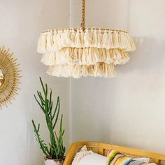 a bedroom with a bed, mirror and hanging light fixture in the corner next to a potted cactus