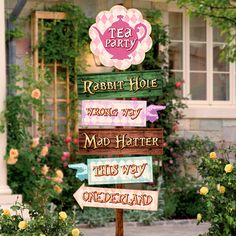 a wooden sign that says tea party, rabbit hole, wrong way, mad hatter, this way, wonderland