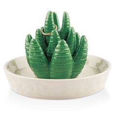 a green plant sitting on top of a white bowl