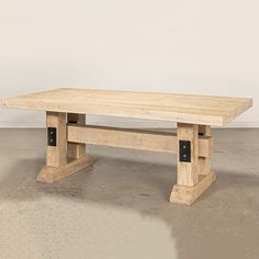 a wooden bench sitting on top of a cement floor in front of a white wall