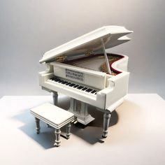 a white piano sitting on top of a table next to a stool and footstool