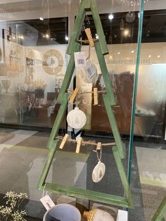 a christmas tree made out of wooden sticks and other items in a display case at a store