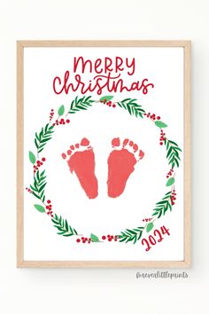 a christmas card with the words merry christmas and two baby footprints in a wreath frame