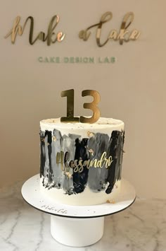 a white cake with black and gold frosting