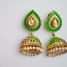 - 18kt yellow gold plating on silver, copper, and brass metal that is lead and nickel free making it body safe - Antique green enamel with pearl drops jhumka with pearl stud - Pushback latch closure - Lightweight and comfortable to wear - Stylish earrings are a traditional design - Elegantly boxed to be given as a gift, or easily stored to be ready for your next occasion Wedding Dual-tone Green Jewelry, Green Kundan Jewelry With Meenakari, Gold Plated Green Jewelry For Diwali, Green Gold Plated Jewelry For Diwali, Green Meenakari Kundan Jewelry, Ceremonial Meenakari Enamel Jewelry, Green Earrings For Diwali Festive, Diwali Green Gold Plated Jewelry, Green Dual-tone Jewelry For Wedding