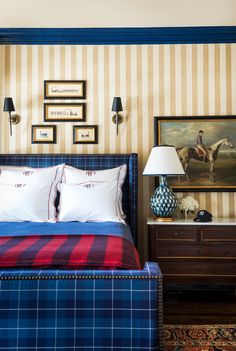 a bed in a bedroom with two lamps on either side of it and pictures above the headboard