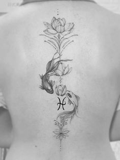 the back of a woman's body with flowers and fish on her lower back