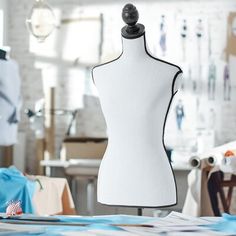 a white mannequin sitting on top of a table