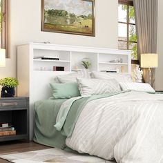 a bedroom with a bed, nightstands and paintings on the wall above it's headboard