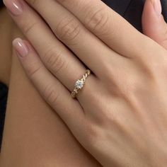 a close up of a person's hand with a diamond ring on their finger