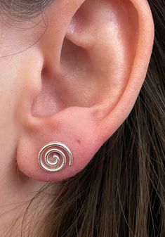 Beautiful textured 925 Sterling Silver Spiral stud earrings. These push back studs look amazing in all light with their delicately brushed finish. Metaphysical Benefits: The spiral is the rhythm of life. It characterizes the creative vital force of human and society, a symbol of unity of generations, and spiritual and moral growth of man. It means the life order, the symbol of continuity, development, motion, and journey into the unknown. Spiral Stud Earrings, Cute Unique Earrings, Cute Studs Earrings, Uneven Ear Piercings, Pretty Silver Earrings, Gold Spiral Jewelry, Ear Piercings Grunge, Cool Silver Jewelry, Spiral Symbol Meaning