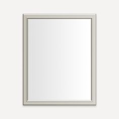 a white framed mirror on a wall with a light gray border around the frame and bottom edge