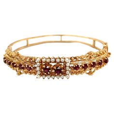 Simply Beautiful! Finely detailed Victorian Revival Hinged Cuff Bangle Bracelet. Hand set with Garnets and Seed Pearls. Hand crafted in 14 Karat Yellow Gold. Approx. Dimensions: 2.35” l x 2.66” w. The Bracelet is in excellent condition and was recently professionally cleaned and polished. More Beautiful in real time! Don’t miss this original Rare Beauty and Illuminate your look with this Family Heirloom Quality Keepsake, to have and to hold Forever! Gold Cuff Bangle, Victorian Revival, Cuff Bangle Bracelet, Gold Cuffs, Seed Pearl, Family Heirloom, Cuff Bangles, Simply Beautiful, Bangle Bracelet