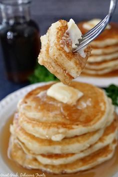 a stack of pancakes with butter on top and syrup being drizzled over them