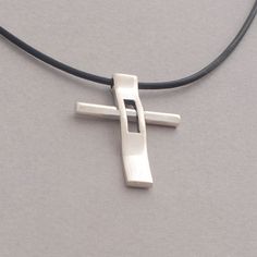 "Rejoice in your commitment to the faith with this modern cross necklace. Wear your Christianity with pride and show the world the beauty that lies within each time you get dressed. This modern cross necklace is custom handmade in majestic detail from sterling silver. Polished to a brilliant shine, it is suspended from a length of black leather cord to complete the look. It makes a fabulous gift and will be a heartwarming addition to his existing jewelry collection. Cross measures 3.4 cm x 2.5 c Modern Crucifix Cross Necklace As Gift, Modern Crucifix Necklace As Gift, Modern Cross Necklace As A Gift, Cuttlefish Casting, Mens Cross Necklace, Sterling Silver Cross Necklace, Sunflower Jewelry, Silverware Jewelry, Golden Jewelry