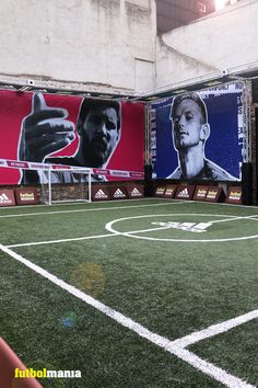 an indoor soccer field with posters on the wall